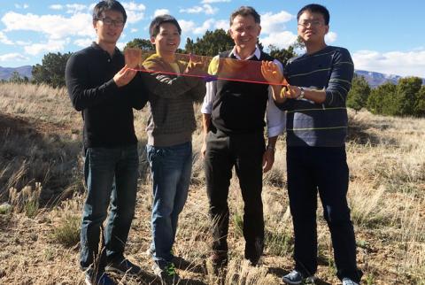 Los Alamos Center for Advanced Solar Photophysics researchers hold a large prototype solar window. From left to right: Jaehoon Lim, Kaifeng Wu, Victor Klimov, Hongbo Li.